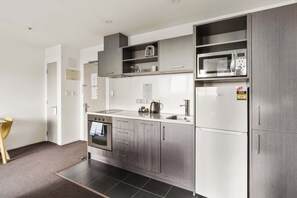 Una cocina moderna con electrodomésticos de acero inoxidable, horno integrado y microondas.