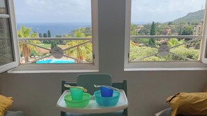 Ein Zimmer mit Blick auf Pool und Grünanlage, ein kleiner Tisch mit Schalen und ein Balkongeländer.