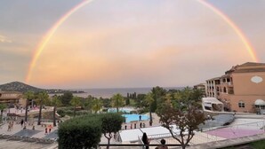 Ein Resort mit Pool, Palmen und Meerblick.