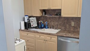 A kitchen with wooden cabinets, a sink, a stove, and a dishwasher. - Cozy 3-bedroom townhome w/ AC in pleasant Paramus. World Cup, negotiable rates (Paramus)