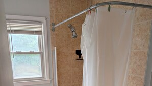 A bathroom with a bathtub, toilet, and window. - Cozy 3-bedroom townhome w/ AC in pleasant Paramus. World Cup, negotiable rates (Paramus)