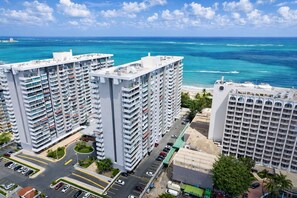 A high-rise hotel with multiple floors, a parking area, and a view of the ocean. - Beachside at Isla Verde (Carolina)
