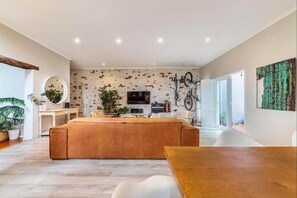 Una sala moderna con un sofá grande, una mesa de comedor y un televisor.
