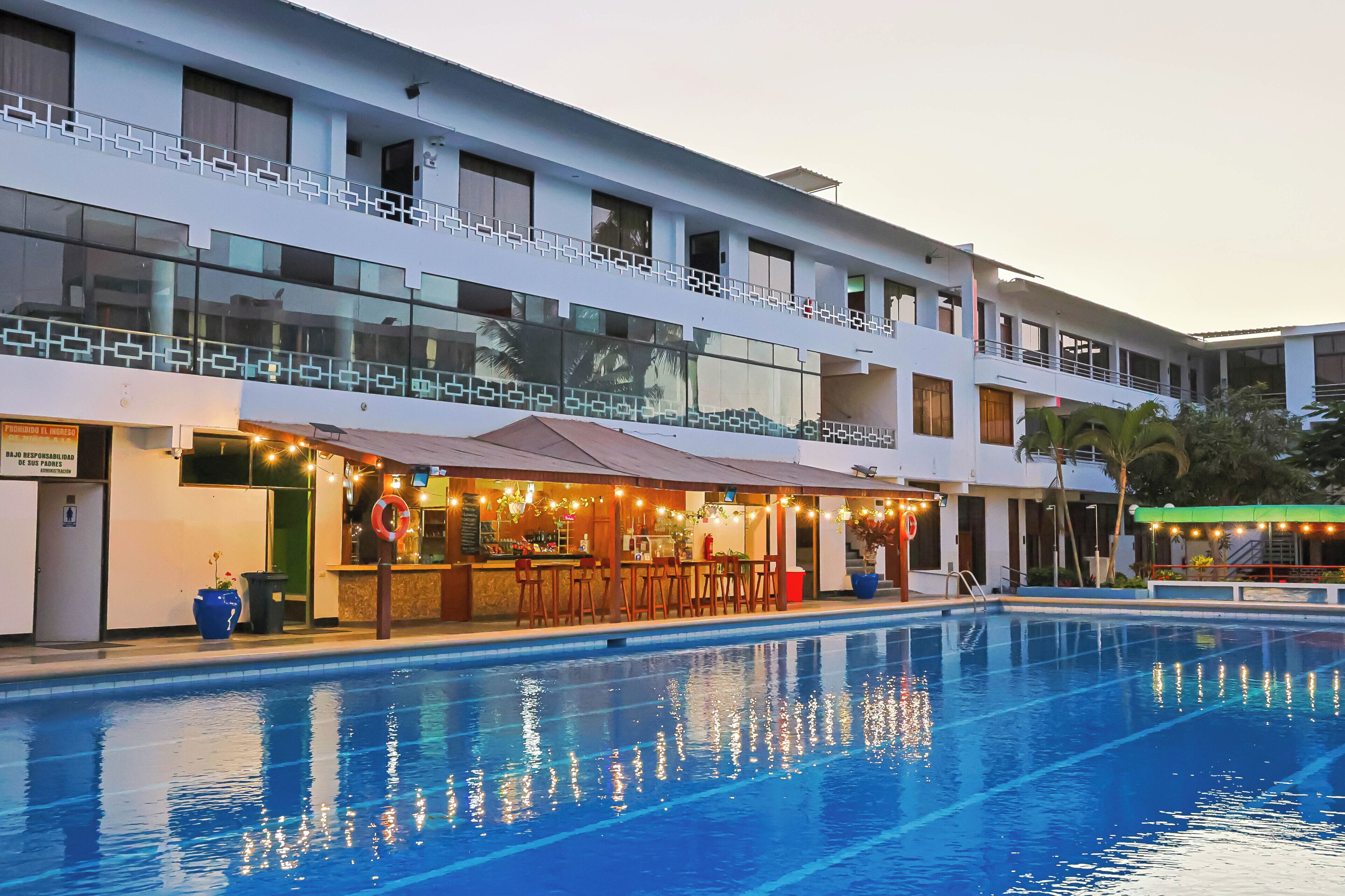Et hotel med swimmingpool, barområde og flere balkoner.