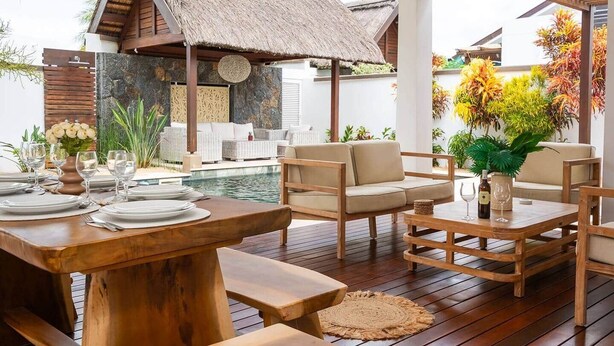 An outdoor dining area with wooden furniture, a pool, and tropical plants. - Stunning Latanier villa-private pool in Grand Bay (Rivière du Rempart District)