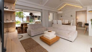 A modern living room with a sofa, coffee table, and a dining area with chairs. - Stunning Latanier villa-private pool in Grand Bay (Rivière du Rempart District)
