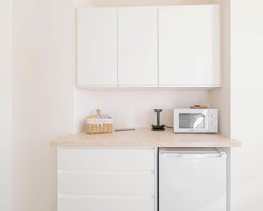 A kitchen with white cabinets, a microwave, a coffee maker, and a small refrigerator. - Apartment Kronplatz 5 (Valdaora di Mezzo)