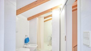 Un baño con ducha, lavabo e inodoro.