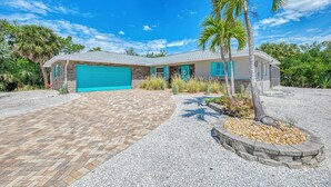 Ein Bungalow mit Garage, Auffahrt und einem angelegten Vorgarten mit einer Palme.