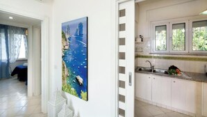 A modern kitchen with white cabinets, a sink, and a window with a view of greenery. - Belvedere Apartment - Breathtaking sea view with terrace in Nerano (Nerano)