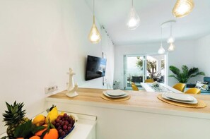 A modern kitchen with a fruit bowl, a flat-screen TV, and pendant lights. - Incanto Apartment - Dream sea view with terrace and garden in Nerano (Nerano)