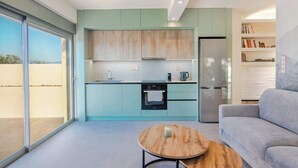 Una cocina moderna con una puerta corrediza de vidrio, horno empotrado y refrigerador.