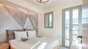 Un dormitorio con cama, mesita de noche, ventana y puerta.