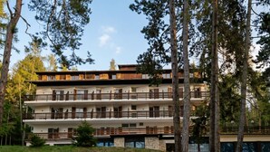A multi-story building with balconies, surrounded by trees. - Garnì Pirata (Cavareno)