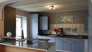 Eine moderne Küche mit blauen Schränken, einer Arbeitsplatte und einer Hängeleuchte.