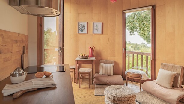 Een gezellige kamer met houten wanden, een kitchenette, een eethoek en een balkon met uitzicht.