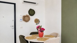 A dining area with a round table, four chairs, a vase with flowers, and wall decorations. - Bright, refined apartment in La Marsa (Marsa)