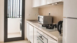 A modern kitchen with a microwave, stove, and refrigerator. - Bright, refined apartment in La Marsa (Marsa)