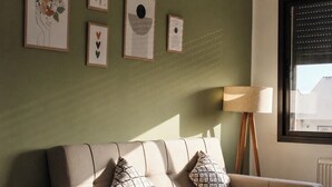 A living room with a sofa, two patterned pillows, a floor lamp, and framed artwork on the wall. - Bright, refined apartment in La Marsa (Marsa)