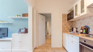 A modern kitchen with white cabinets, a microwave, and a coffee maker. - Le Case di Sonia Maison Mami' (Fucecchio)
