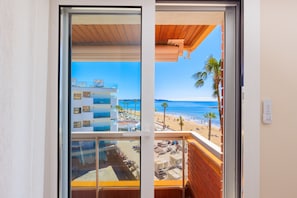 Een balkon met uitzicht op een strand en een gebouw aan de overkant van het water.