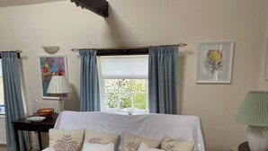 A room with a white sofa, a window with curtains, a lamp, and a framed picture on the wall. - Kent Apartment 2 bed in Sandwich, With Free Parking (Sandwich)