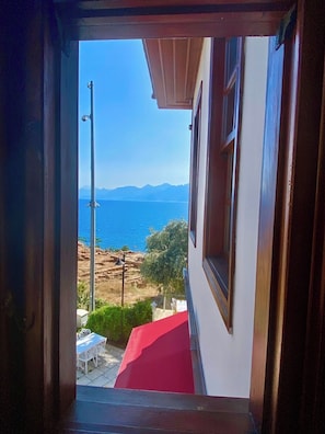 A view through a doorway to a balcony overlooking a coastal landscape with mountains in the distance. - Ulivo Hotel (Antalya)