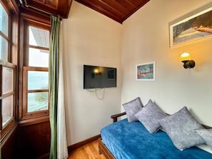 A room with a bed, a television mounted on the wall, a painting, and a window with curtains. - Ulivo Hotel (Antalya)