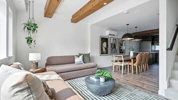 A modern living room with a sofa, coffee table, and hanging plants.