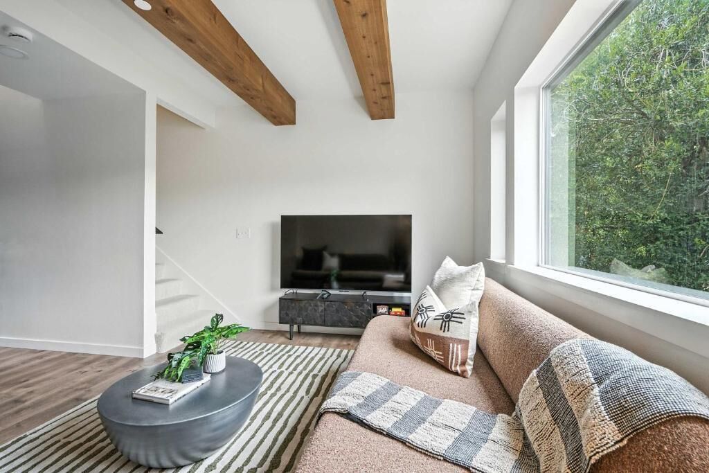 A modern living room with a sofa, a coffee table, and a TV.