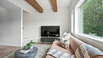 A modern living room with a sofa, a coffee table, and a TV.