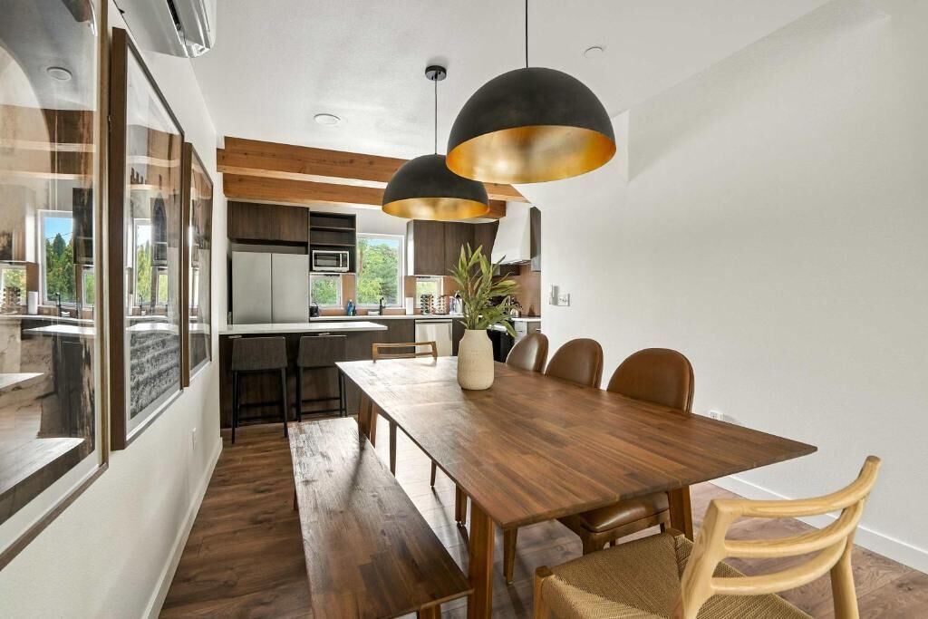 Una cocina moderna con armarios de madera, una isla central e iluminación colgante.