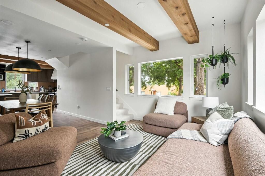 A modern living room with a sofa, coffee table, and hanging plants.