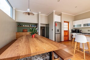 Une cuisine moderne avec un îlot central en bois, des appareils en acier inoxydable et une grande fenêtre.