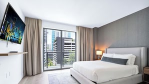 A modern hotel room with a large bed, a flat-screen TV, a city view, and a balcony. - Brickell Building City Centre - We Host (Miami)