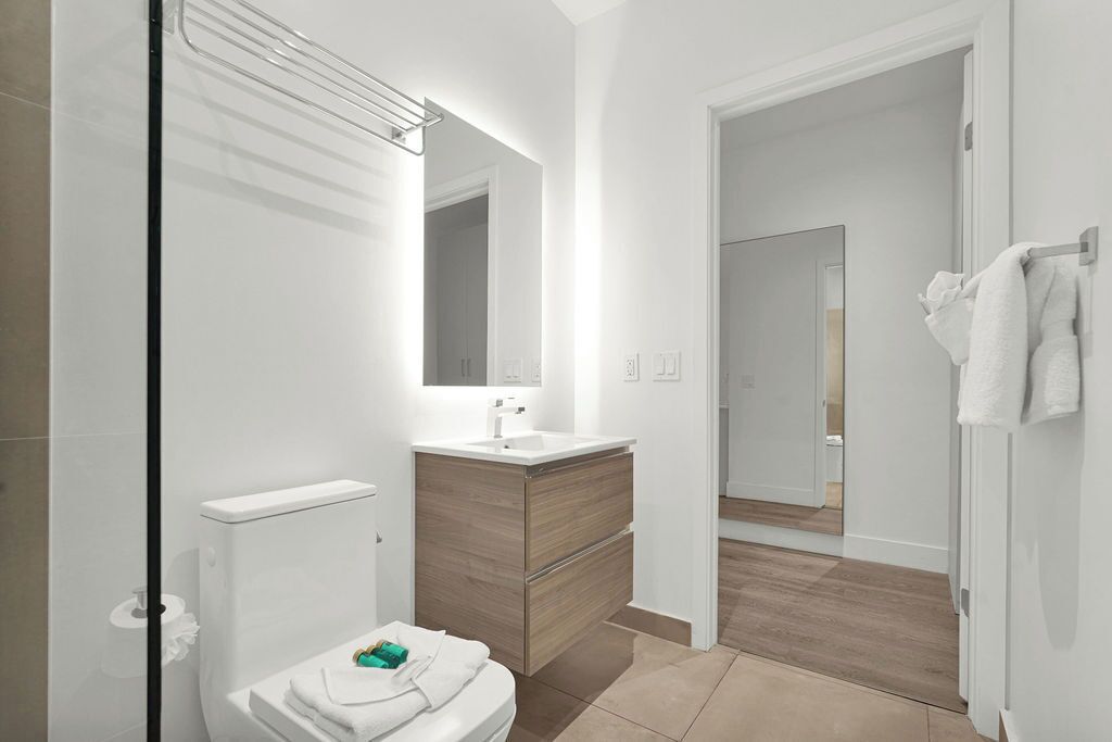 Un baño moderno con inodoro, lavamanos y tocador.