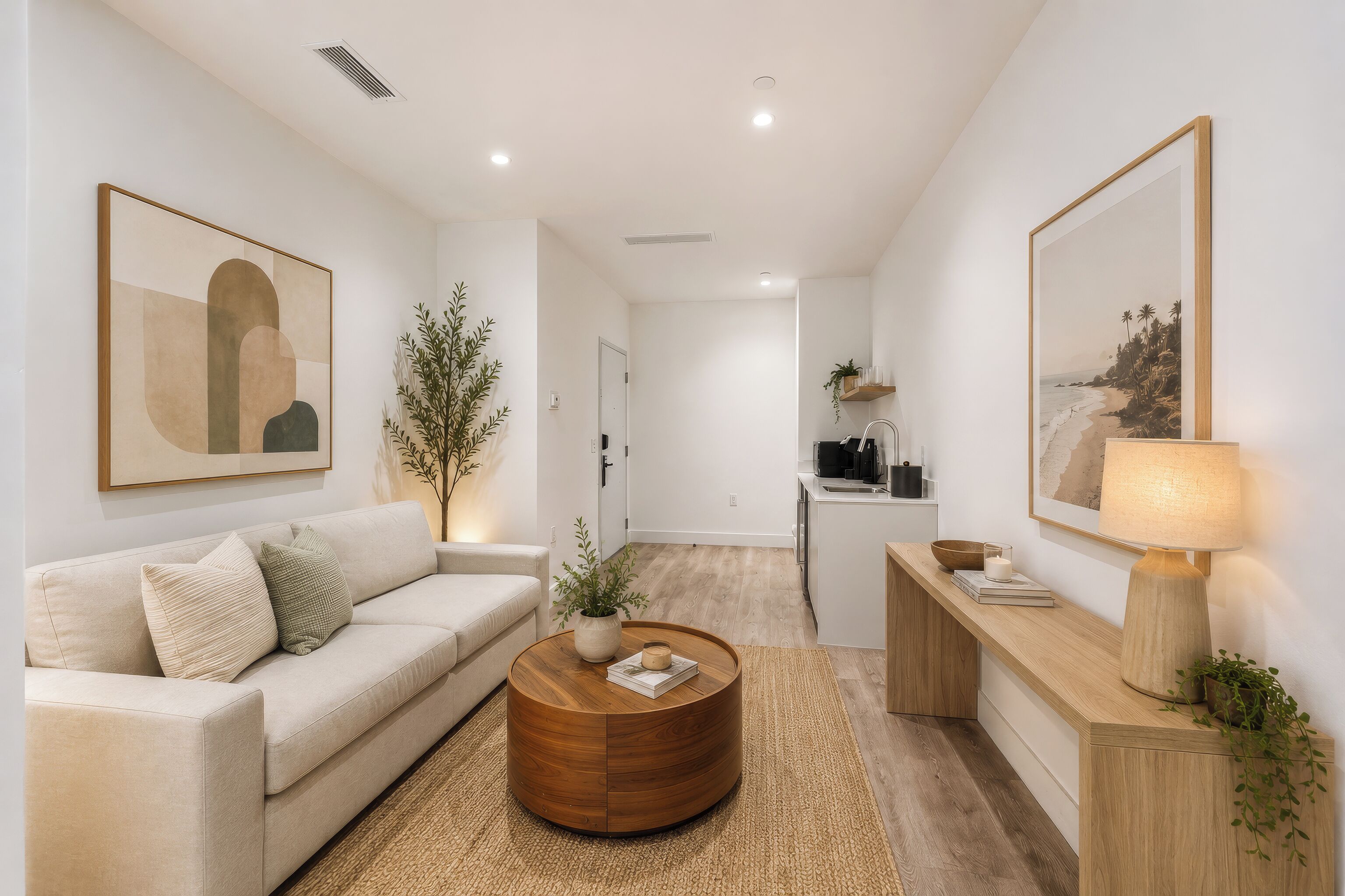 A modern living room with a sofa, coffee table, and artwork on the walls.