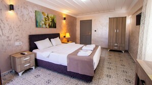 Un dormitorio con cama, mesitas de noche, un armario y un cuadro en la pared.