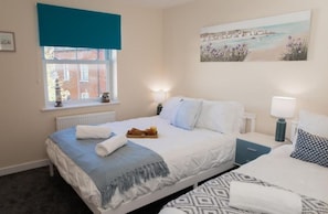 Ein Schlafzimmer mit Bett, Nachttischen, einem Fenster mit Blick und einem Bild an der Wand.