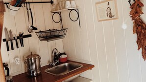 Eine Küche mit Spüle, Wasserkocher, Kaffeemaschine und einer Küchenutensilien-Leiste.