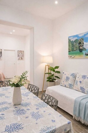 A room with a dining table, a sofa, a lamp, a painting, and a door. - Casa Porta Nuova very close to Palazzo dei Normanni and Palermo Cathedral (Palermo)