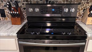 A kitchen with a stainless steel stove, oven, and a stone backsplash. - South Alabama Country Home With A Swimming Pool (Fairhope)