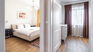 Une chambre à coucher avec un lit, une table de chevet et un luminaire fixé au mur.
