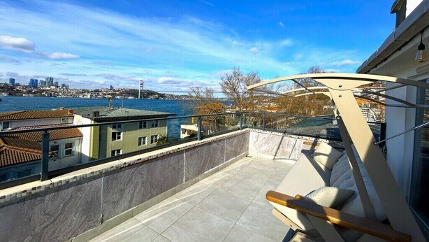 Ein Balkon mit Blick auf eine Stadtlandschaft und ein Gewässer.