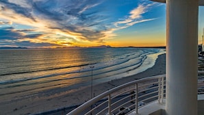 A beach view with a railing, a clear sky, and a sunset. - 75 Cap D'Azur (Cape Town)