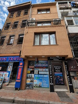 Un edificio de varios pisos con una agencia de viajes, un servicio de cambio de divisas y servicios de bienes raíces.