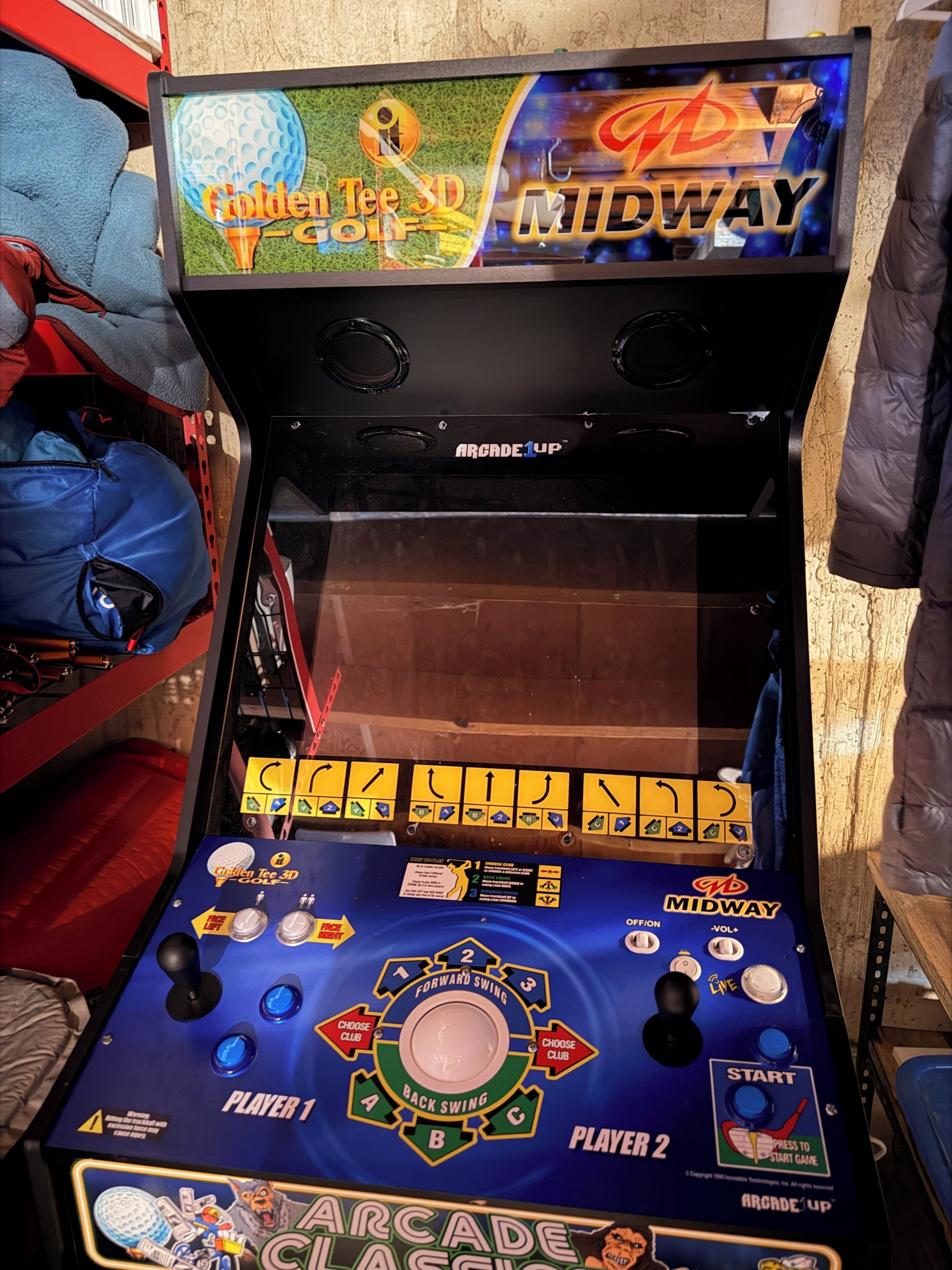 A 3D golf arcade machine with a 'Golden Tee' and 'Midway' theme, featuring two player controls and a screen displaying game options.