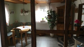 A cozy room with a wooden dining table, chairs, a hanging light fixture, and a view of the outdoors. - Holiday Home 'Ferienhaus Pacco' with Shared Terrace, Shared Garden and Wi-Fi (Wermelskirchen)