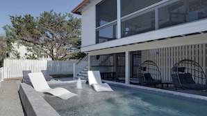 A modern house with a swimming pool, outdoor seating, and a white fence. - Palmwood Haven (Tybee Island)