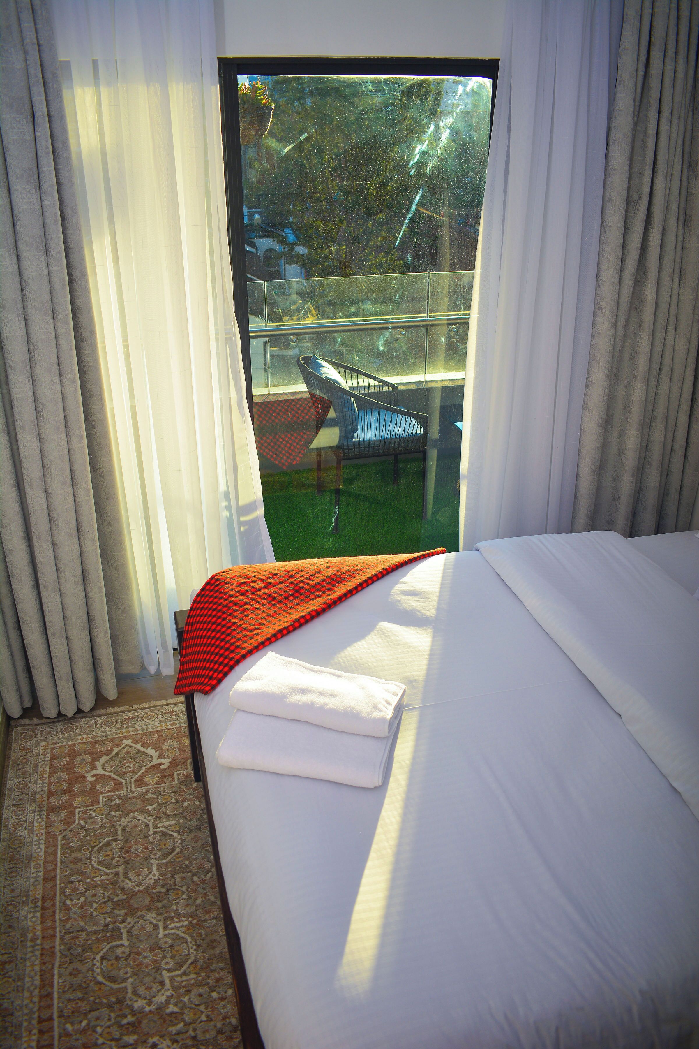 Ein Hotelzimmer mit Bett, Blick auf einen Pool und einem Balkon.